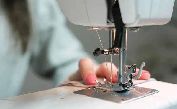 Женщина пришивает легкую ткань к швейной машинке крупным планом . — стоковое фото