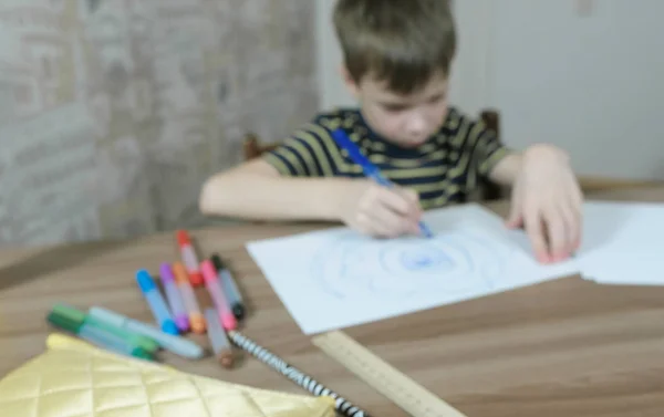 Fiú rajzolása ovális kék jelölővel fehér papírra. Blur. — Stock Fotó