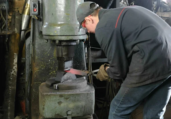 A fazer a faca de metal na forja. Homem usando martelo pneumático para moldar metal quente . — Fotografia de Stock