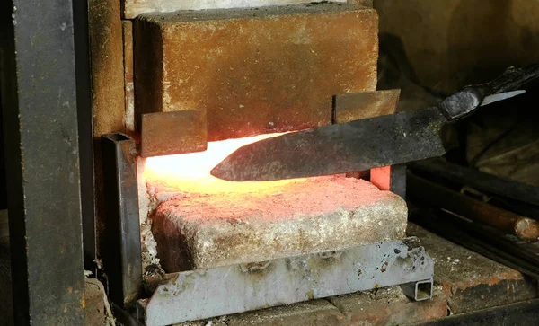 A fazer a faca de metal na forja. Aquecimento de tarugos de metal no forno . — Fotografia de Stock