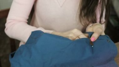 Kadının elleri deri dikilmektedir için mavi ceket ekle ve parmağına iğne vurdu.