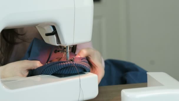 Gros plan de la veste coincée dans une machine à coudre. La couturière essaie de le faire sortir . — Video