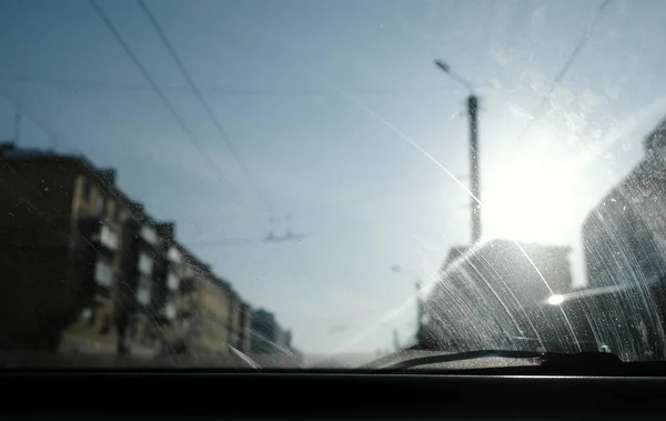車から街を見る。汚れたフロント ガラスに焦点を当てる. — ストック写真