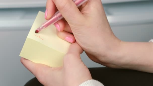 Gros plan womans mains écrire sur des feuilles de papier autocollant jaune mots ont un plaisir . — Video