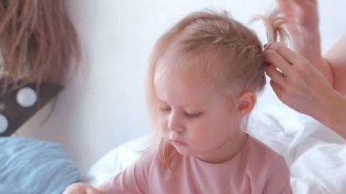 Genç çekici sarışın anne küçük sevimli kızı o keçe-kalemle resim ise pembe elbiseler için örgüler saç kravat