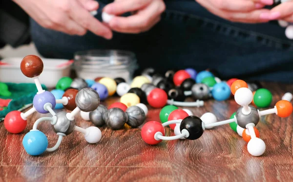 Modelos de moléculas de um construtor plástico e mãos de pessoas . — Fotografia de Stock
