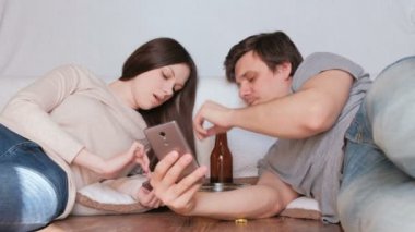 Çift erkek ve kadın onların hareket eden telefon içinde enterne browsing. Adam besleme kadın cips. Kadın cep telefonu konuşuyor.