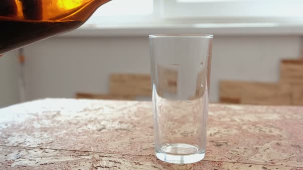 Cerveja escura é derramada de uma garrafa em um copo . — Vídeo de Stock