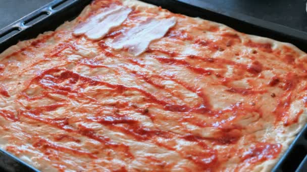 Koch bereitet Pizza zu. Nahaufnahme Frauenhände legen Fleisch zu Teig mit Sauce. — Stockvideo