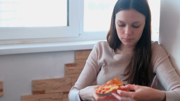 Jonge vrouw is een plak van eigengemaakte pizza eten. — Stockvideo