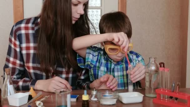 Experimentos de química en casa. Mamá e hijo hacen una reacción química con la liberación de gas en el tubo de ensayo . — Vídeos de Stock