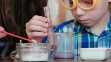 Kimya deneyleri evde. Anne ve oğlu gaz kimyasal bir reaksiyon ile belgili tanımlık serbest bırakmak içinde belgili tanımlık deney tüpü ve kabı olun.