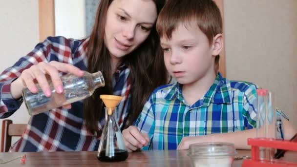 Chemické pokusy doma. Žena, nalití vody do baňky z láhve pomocí nálevky. — Stock video