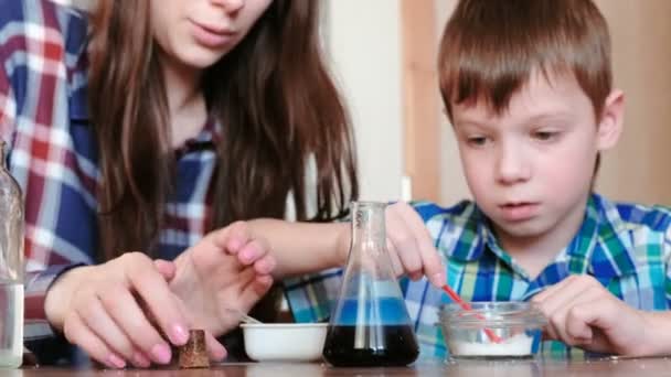 化学实验在家里。妈妈和儿子在瓶子里放出气体, 做出化学反应。. — 图库视频影像
