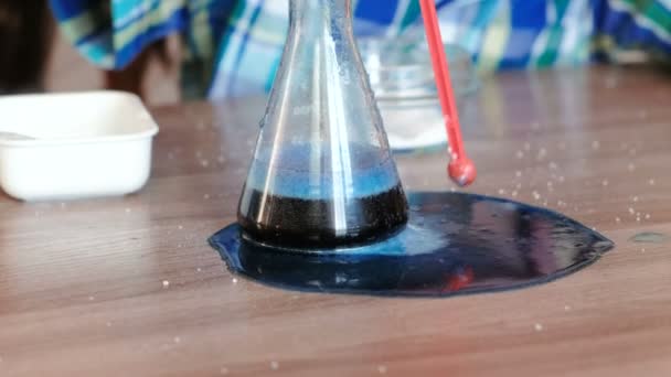 Chemistry experiments at home. Mom and son make a chemical reaction with the release of gas in the flask. Mom clean the table. — Stock Video