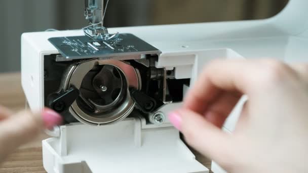 Close-up female hands disassemble the sewing machine and clean it from dust with a brush. — Stock Video