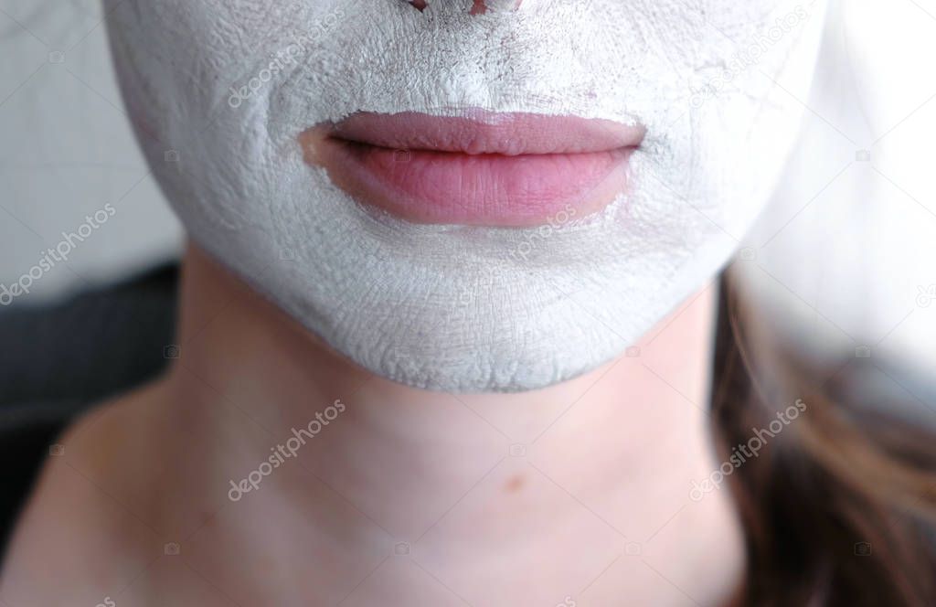 Clay mask on a womans face. Close-up lips and chin.