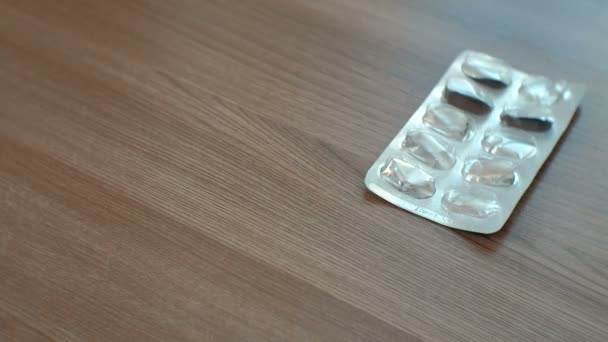 Las ampollas de pastillas caen sobre la mesa. Primer plano. . — Vídeos de Stock