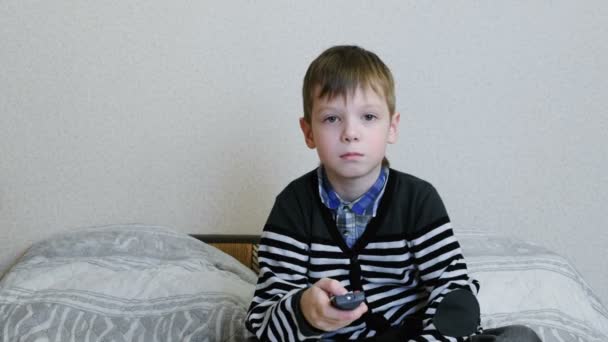 Kijken tv Joyful jongen is Tv-kijken en wordt overgeschakeld van de kanalen. — Stockvideo