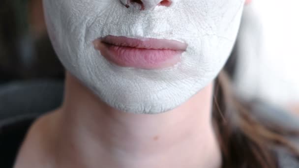 Lägg masken på en kvinnas ansikte. Närbild läppar och haka. Läpparna rör sig i olika riktningar. — Stockvideo