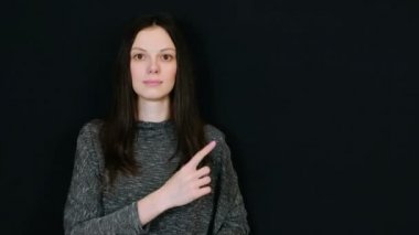 Kadın gülümsüyor ve parmak yukarı sağa tarafından gösterir. Metin için yer.