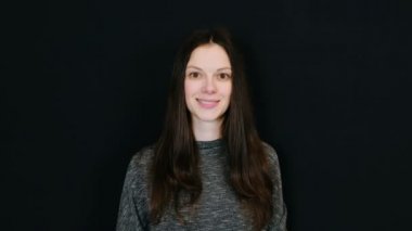 Genç esmer kadın bir sürü kamera siyah arka plan bakarak öpücük gönderir. Metin için yer.