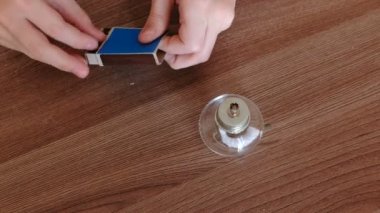 Evde kimya üzerinde deneyler. Çocuklar eller bir maç ile yangın yanan alkol lamba ayarlar.