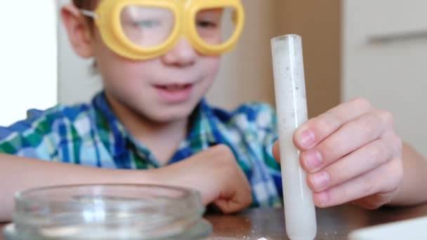 Experimentos de química en casa.Reacción química con la liberación de gas en el tubo de ensayo en las manos del niño . — Vídeos de Stock