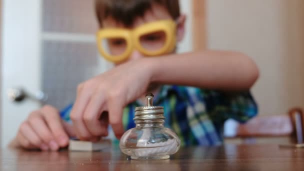 Experimenten op chemie thuis. Jongen stelt de brandende alcohol lamp in vuur en vlam met een wedstrijd. — Stockvideo