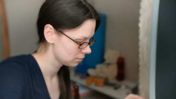 Femme brune dans des lunettes tape quelque chose sur le clavier de travail sur ordinateur . — Video