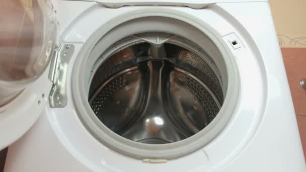 Laundry. Man puts white linen in the washing machine. Closeup hand. — Stock Video