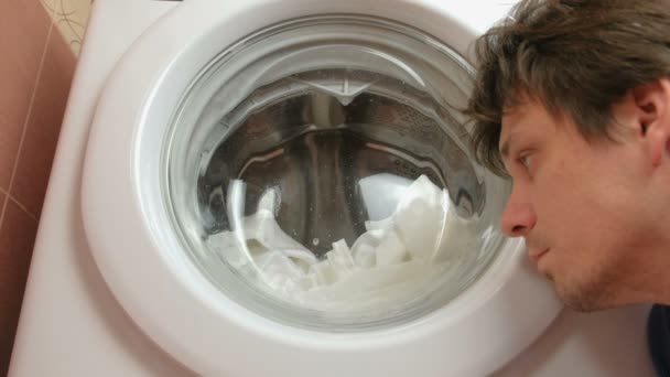 Man maakt diagnostiek van wasmachine. Luistert naar de werking van de wasmachine. — Stockvideo