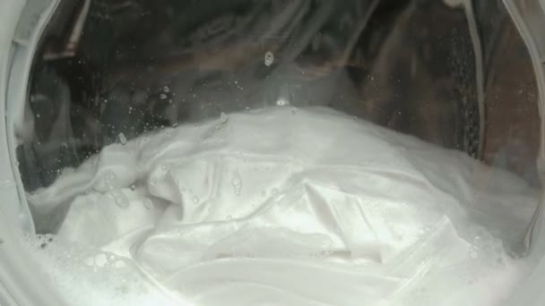 Біла білизна миється в пральній машині крупним планом . — стокове відео