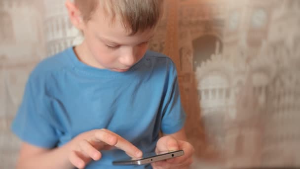 Επτά-έτος-παλαιό αγόρι βιαστικά Διαδίκτυο στο κινητό του τηλέφωνο με σοβαρό πρόσωπο. — Αρχείο Βίντεο