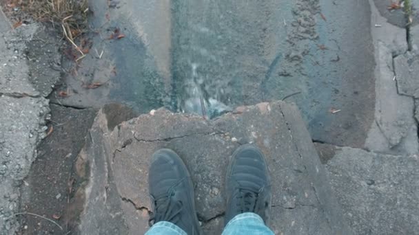 El hombre está buscando en la descarga de la contaminación del agua del desagüe. Primer plano mans piernas . — Vídeos de Stock