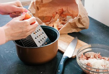 Kadının eller üzerinde tencerede rende havuç losyonları.