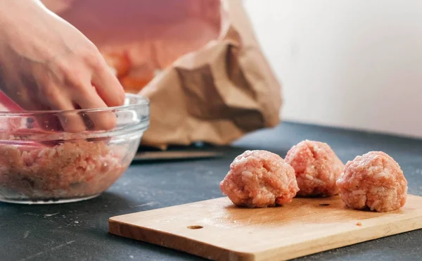 Close-up of a womans hands making meatballs of minced meat with rice and put it on a wooden board. — Stock Photo, Image