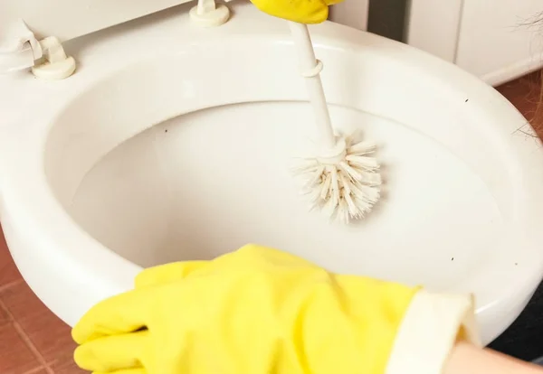 Womens handen sluiten - omhoog in gele rubberen handschoenen wassen het toilet met borstel. — Stockfoto