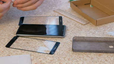 Kırık güvenlik camı mobil telefon yeni adam değişiklikleri. Belgili tanımlık telefon perde bir bezle siliyor. Yakın çekim yakışıklı.