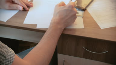 Adam bir irade yazıyor ve çekmeceden bir silah çeker ve kendini vuruyor. El closeup mans