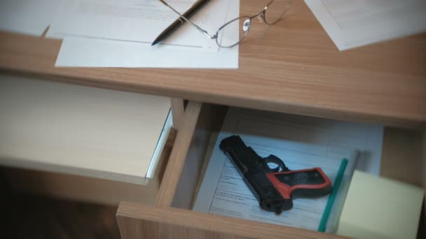 Testament, stylo, lunettes sur la table et pistolet dans un tiroir de table . — Video