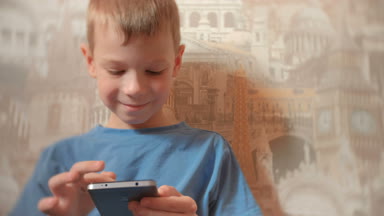 Cep telefonunda oyun 7 yaş çocuk gülümseyen.