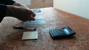 Adam onları masaya döşeme para sayar. Eller.