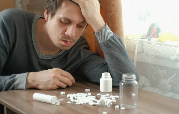 Man has a lot of pills and falls asleep. The concept of depression, suicide and danger. — Stock Photo, Image
