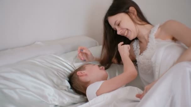 Máma a syn hrát s sebou ležící v posteli a ráno.