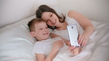 Anne ve oğlu selfie cep telefonunu al. Anne oğlunu hugs.