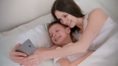 Anne ve oğlu selfie cep telefonunu al. Onlar mutlular.