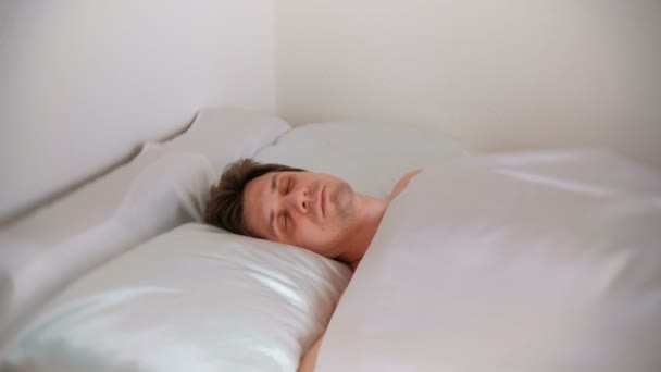 Человек спит в постели один. . — стоковое видео