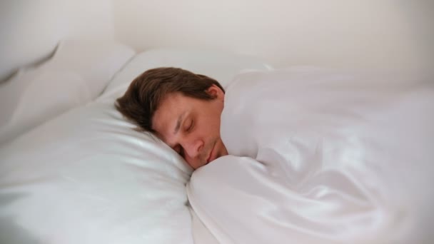 El hombre duerme y se despierta por la mañana . — Vídeos de Stock