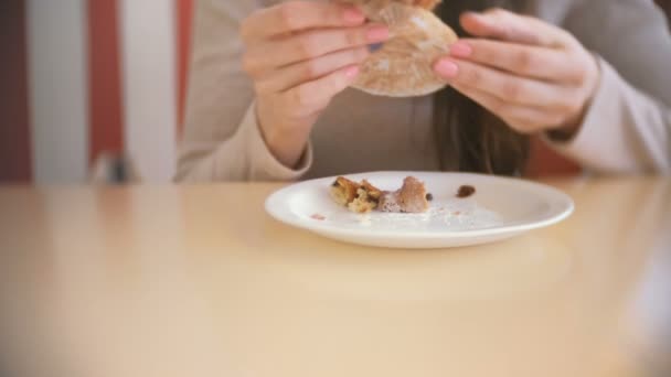 Una donna che mangia un muffin con uvetta. Primo piano di mani di donne . — Video Stock